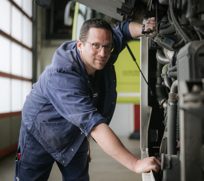 Zuverlässigkeit Ein Mechatroniker prüft etas an einem Bus mithilfe eines Gerätes